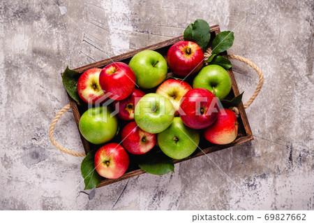 Ripe red and green apples in wooden box. Ripe red and green apples in wooden box. 69827662
