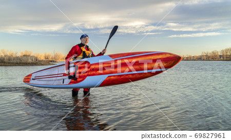 paddling stand up paddleboard in winter 69827961
