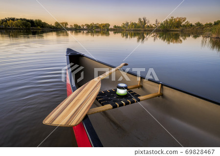 red canoe on a lake shore red canoe on a lake shore 69828467
