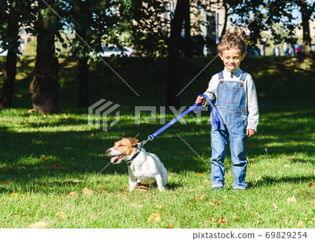 Amusing kid boy copying and teasing dog with tongue out 69829254