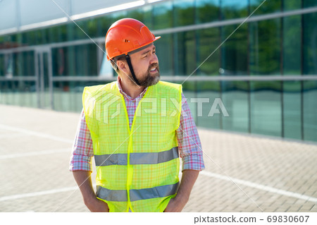 foreman in vest and protective helmet foreman in vest and protective helmet 69830607