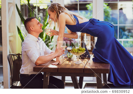 romantic dinner. girl with glass stands on table. 69830952