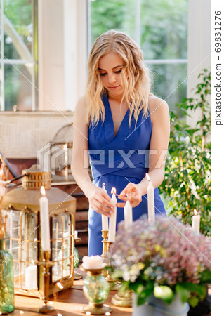 girl lit candles with match. romantic dinner. girl lit candles with match. romantic dinner. 69831276