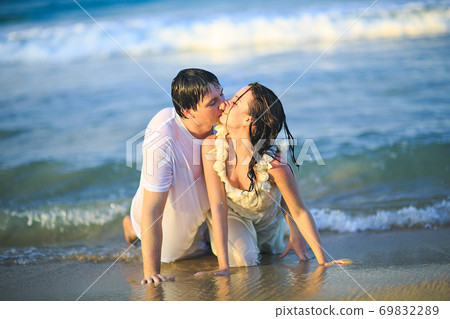 newlywed in wet clothes flirting lying on beach. newlywed in wet clothes flirting lying on beach. 69832289