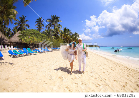 tourists walk through empty sandy sea beach. tourists walk through empty sandy sea beach. 69832292