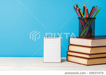 Cup of color pencils and stack of books Cup of color pencils and stack of books 69835479