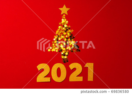 Christmas tree made of gold confetti on red background Christmas tree made of gold confetti on red background 69836580