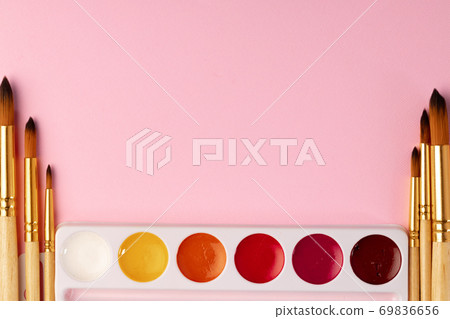 Watercolor paint with set of brushes on pink background 69836656