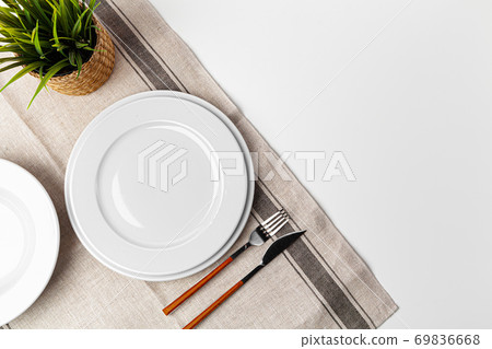 Fork, knife and plate on towel. Isolated on white background. Fork, knife and plate on towel. Isolated on white background. 69836668