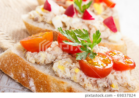 Closeup of crusty baguette with mackerel or tuna fish paste, healthy nutrition Closeup of crusty baguette with mackerel or tuna fish paste, healthy nutrition 69837824