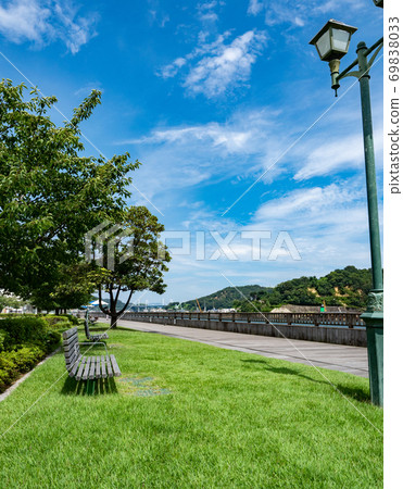 [Hiroshima Prefecture] A lawn open space with a promenade and benches in front of Onomichi Station 69838033
