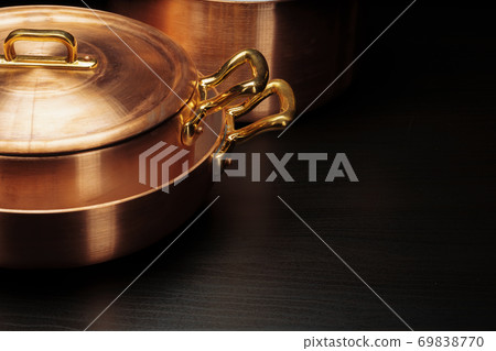 Shiny vintage copper cookware over dark background Shiny vintage copper cookware over dark background 69838770