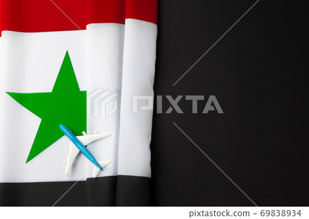 Small toy plane over the fabric flag of Syria Small toy plane over the fabric flag of Syria 69838934
