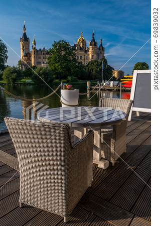 Empty chairs in cafe with a beautiful castle in Schwerin in the background. 69839032