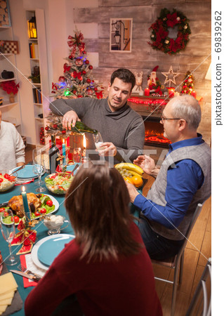 Young man pouring wine to his father Young man pouring wine to his father 69839262