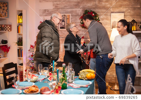 Cheerful young man greeting his mother Cheerful young man greeting his mother 69839265