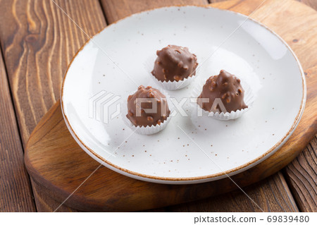 Small chocolate sweets with nuts close up Small chocolate sweets with nuts close up 69839480