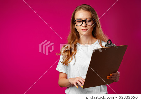 Young beautiful smiling woman standing and holding clipboard 69839556