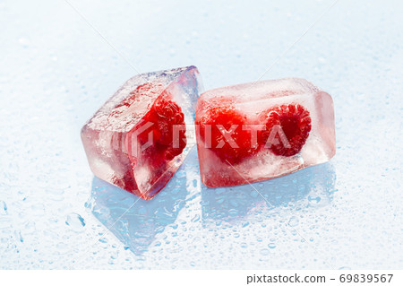 Ice cubes with frozen berries inside close up 69839567