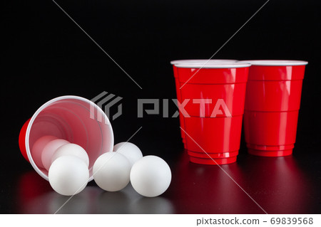 Red plastic cups and ball for game of beer pong 69839568
