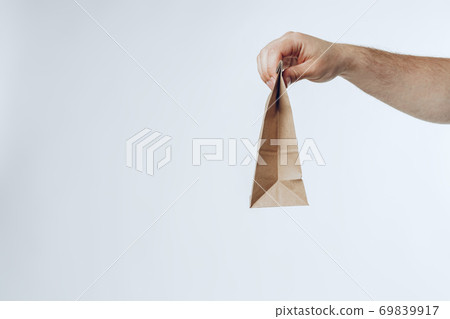 Courier hands giving packed food delivery close up Courier hands giving packed food delivery close up 69839917