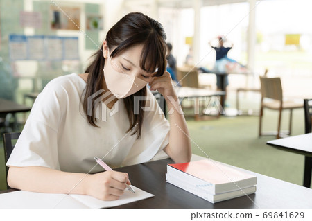 Woman studying with a mask 69841629