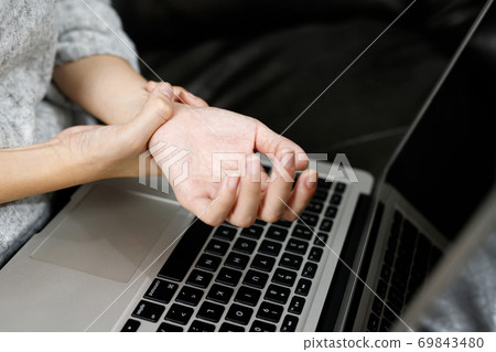 Hand pain woman She is working on the computer 69843480