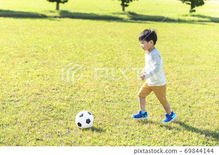 A boy playing with a soccer ball 69844144