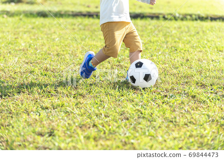 Boy playing with a soccer ball without a face 69844473