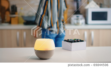 Woman in the kitchen with essential oils diffuser 69844506