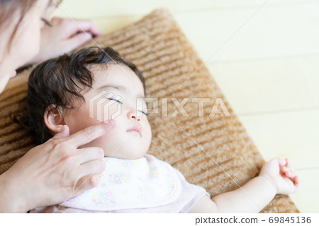 Sleeping baby and mom's hands 69845136
