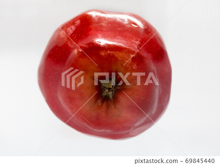 A red apple on a shelf in an fridge. One fresh apple in an refrigerator. A red apple on a shelf in an fridge. One fresh apple in an refrigerator. 69845440