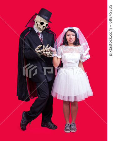 Grim Reaper holds hand of bride 69845835