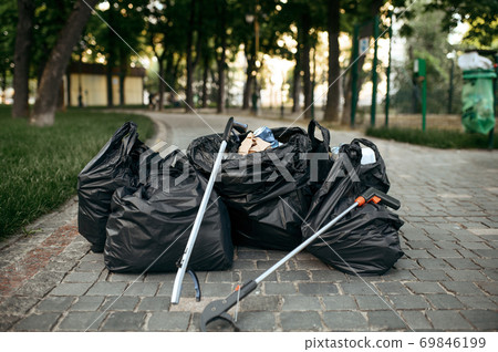 Full trash bags in park, volunteering motivator Full trash bags in park, volunteering motivator 69846199