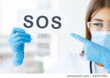 The doctor holds a form with the text sos The doctor holds a form with the text sos 69847960