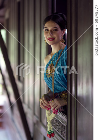 Women wearing Thai national costumes Standing by the window of a Thai house 69848377