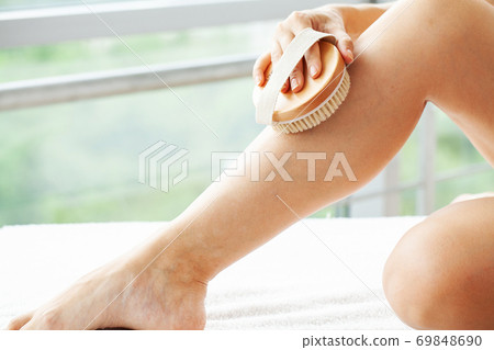Beautiful young woman with massage brush in bathroom Beautiful young woman with massage brush in bathroom 69848690