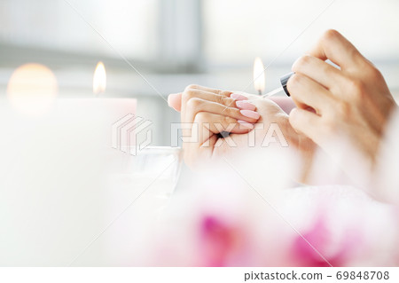 Happy pretty woman making manicure when resting at home Happy pretty woman making manicure when resting at home 69848708