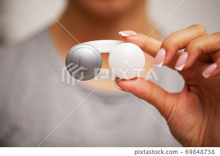 Woman holding plastic container with contact lenses 69848738