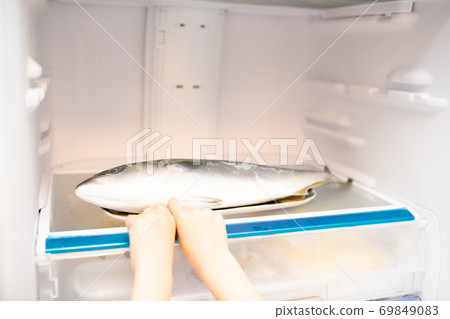 Child's hand trying to take out the fish in the refrigerator Child's hand trying to take out the fish in the refrigerator 69849083