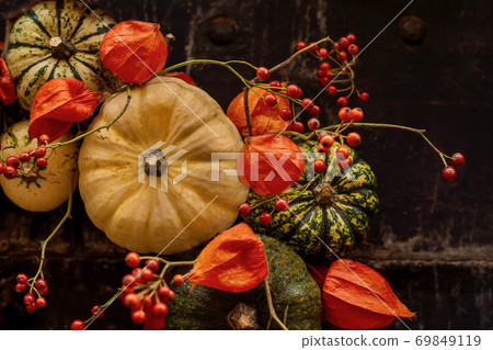 Handmade wreath of small pumpkins and zucchini on a vintage door Handmade wreath of small pumpkins and zucchini on a vintage door 69849119