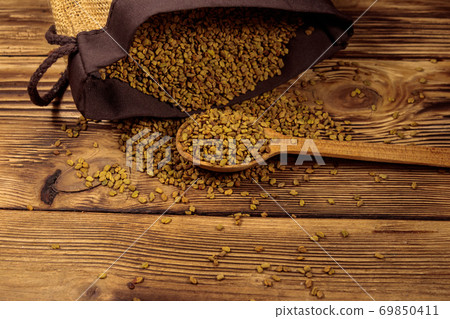 Fenugreek seeds on wooden table Fenugreek seeds on wooden table 69850411