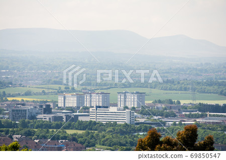 Buildings on the outskirts of Edinburgh overlooking the hills and hazy mountains in the distance 69850547
