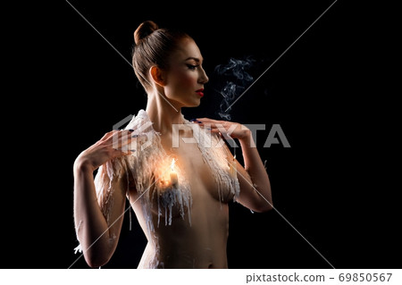 Naked female model with candles on breast Naked female model with candles on breast 69850567