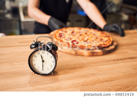 Close up alarm clock with pizza and backer 69851419
