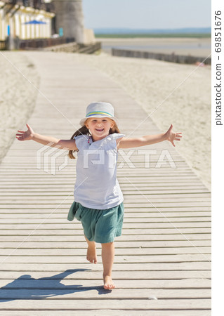 Little girl running on the beach of ocean Little girl running on the beach of ocean 69851676