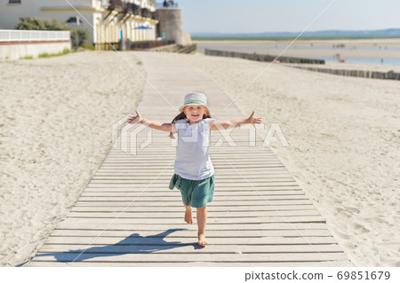 Little girl running on the beach of ocean Little girl running on the beach of ocean 69851679