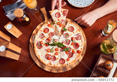 Girl taking slice of pepperoni pizza 69851772