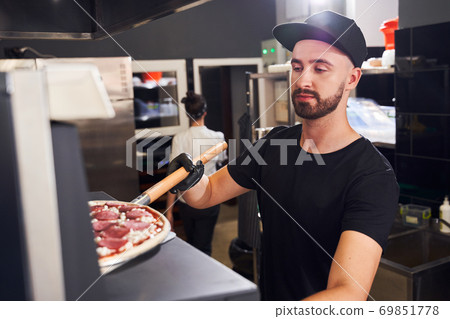 Pizzaiolo with beard making a Pizza Pizzaiolo with beard making a Pizza 69851778