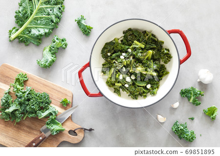 Sauteed kale with garlic in cast iron pan on kitchen table, healthy food concept, superfood 69851895